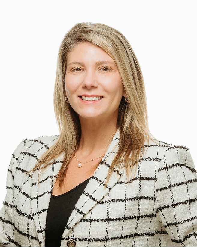 Studio portrait of Ashley Rich wearing a checked blazer against a white background.